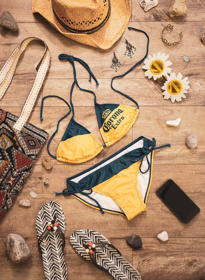 Ladies Corona Bikini- Corona Extra (Blue & Gold) String Bikini Lifestyle Photo with Tote Bag, Sandals and Sunglasses